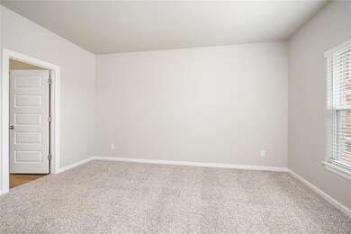 Relax and recharge in this serene and spacious primary bedroom! With soft carpeting and natural light streaming through the windows, it’s the perfect place to unwind
