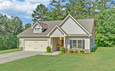 Craftsman-style home featuring board and batten siding, a garage, a shingled roof, concrete driveway, and a front lawn