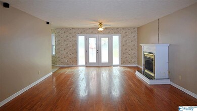 The large living room has hardwood floors, a gas log fireplace, and french doors to the back deck.