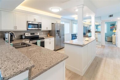 Kitchen featuring light stone counters, sink, whit