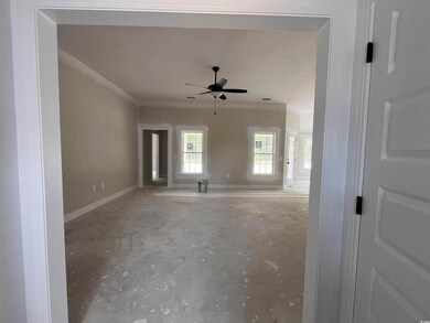 Unfurnished living room featuring a ceiling fan, baseboards, crown molding, and unfinished concrete floors