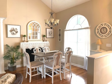 Formal dining area with large window and chandelier.