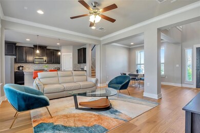 Living area featuring ornamental molding, light wood-style floors, ceiling fan, recessed lighting, and stairway