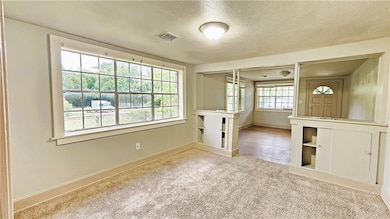 Spare room with visible vents, a textured ceiling,