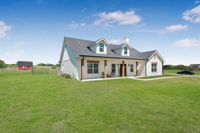 View of front facade featuring a front lawn and a patio area