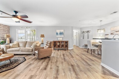 Living room with ceiling fan with notable chandeli