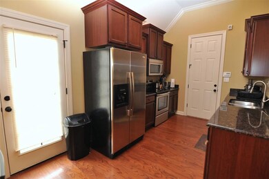 The kitchen is accented with hardwood floor, grani