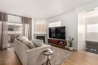 Living room with visible vents, a stone fireplace,