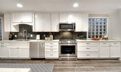 Kitchen with generous white shaker cabinets and stainless steel appliances