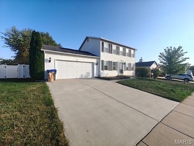 Colonial house featuring a gate, an attached garage, and concrete driveway