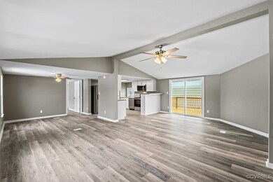 Unfurnished living room with lofted ceiling with b