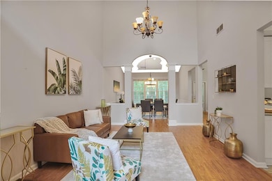 Living area with a chandelier, a towering ceiling, decorative columns
