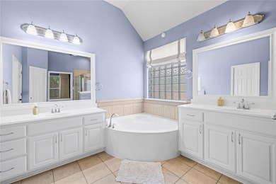Full bath with tile patterned flooring, vaulted c