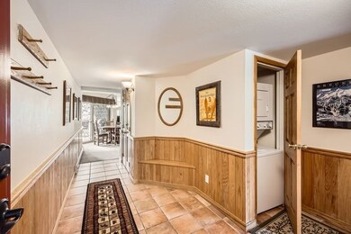 Hall with wainscoting, stacked washer and dryer