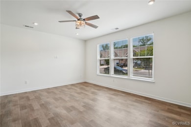 Spare room with wood finished floors, a ceiling fa