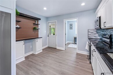 Kitchen featuring dark stone counters, baseboards,