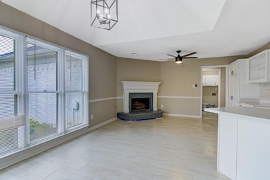 Unfurnished living room featuring baseboards, ceiling fan, and a fireplace
