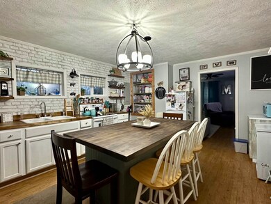 Dining space with sink, crown molding, a textured 