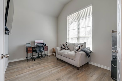Office featuring baseboards, vaulted ceiling, and