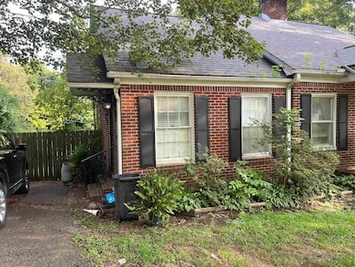 View of front of house featuring roof with shingles, brick siding, and a chimney