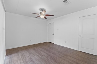 Unfurnished room featuring a ceiling fan, wood fi