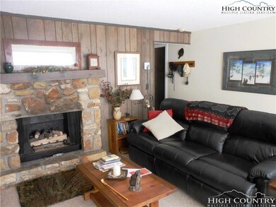Living room with stone fireplace equipped with gas