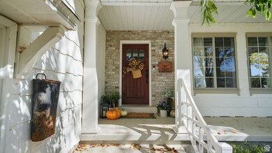 Doorway to property with a porch and brick siding