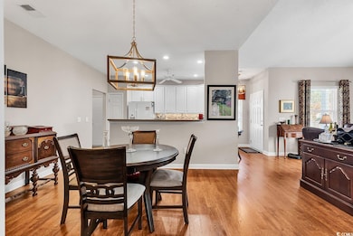 Dining area with ceiling fan with notable chandeli