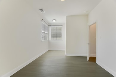 Spare room with dark wood finished floors and bas