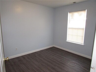 Unfurnished room featuring baseboards, dark wood f