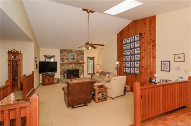 Living Room with a wood burning fireplace and cath