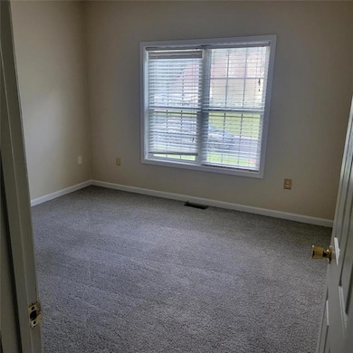 Carpeted empty room featuring baseboards