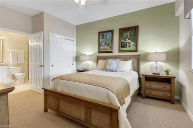 Carpeted bedroom featuring a closet, ensuite bathr
