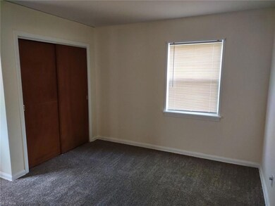 Unfurnished bedroom featuring dark carpet and a closet