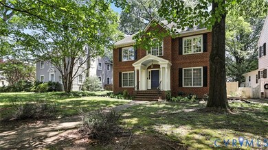 Colonial home featuring brick siding and a front lawn