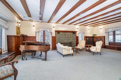 Living room featuring radiator heating unit, carpet floors, and beamed ceiling