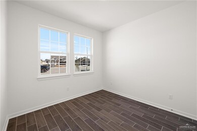 Spare room with dark wood finished floors and baseboards