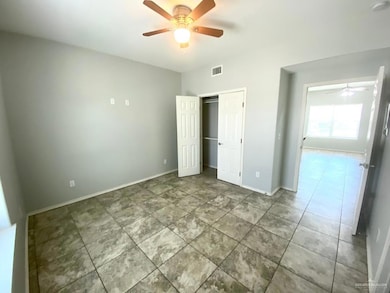 Unfurnished bedroom with tile patterned flooring, visible vents, baseboards, a closet, and a ceiling fan