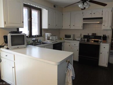 Fully applianced kitchen with tile backsplash.