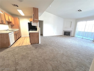 Kitchen featuring white dishwasher, light carpet,