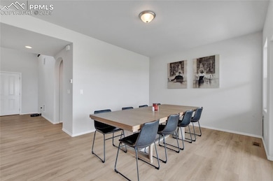 Dining space with baseboards and light wood-style flooring