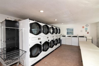 Community laundry room featuring a textured ceiling and separate washer and dryer
