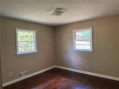 Spare room featuring dark wood-style floors and baseboards