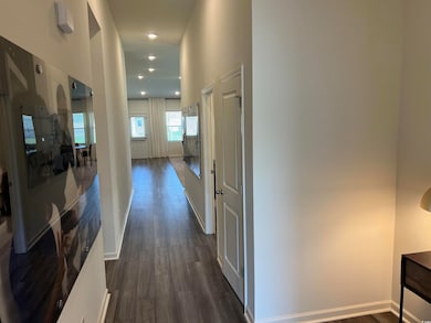 Hallway with dark wood-style flooring and baseboards
