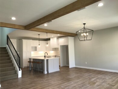 Dining open to the kitchen with designer lighting 