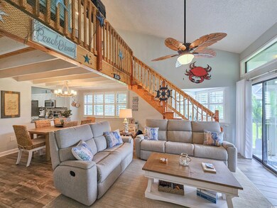 Living room featuring a chandelier, wood finished floors, stairway, healthy amount of natural light, and high vaulted ceiling