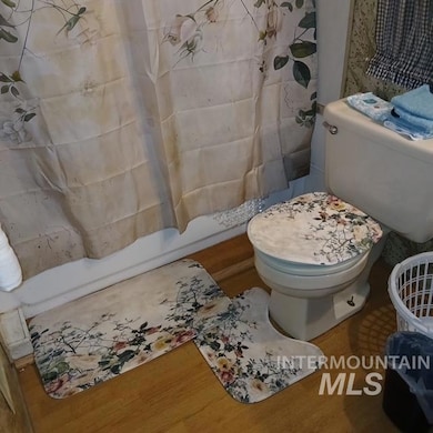 Full bath featuring wood finished floors and shower / tub combo