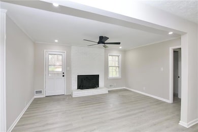 Unfurnished living room with visible vents, a fire