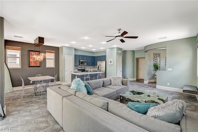 Living room with ceiling fan, baseboards, recessed