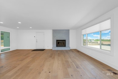 Unfurnished living room with light wood-type flooring, recessed lighting, and a large fireplace